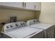 Functional laundry area featuring a Whirlpool washer and dryer and white cabinets for storage at 275 S Highland Ave, Tarpon Springs, FL 34689