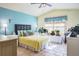 Comfortable bedroom with aqua accent wall, tile floors, natural light, and ceiling fan at 275 S Highland Ave, Tarpon Springs, FL 34689