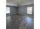 This is a bedroom with gray walls, wood floors, two windows and a ceiling fan at 29123 Crossland Dr, Wesley Chapel, FL 33543