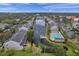 Aerial view showcasing the residential community, pool, lake, and gazebo amidst mature trees and manicured grounds at 297 Countryside Key Blvd, Oldsmar, FL 34677