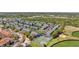 An aerial view of a neighborhood with a pond, athletic fields, tennis courts and parking spaces at 297 Countryside Key Blvd, Oldsmar, FL 34677