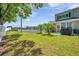 A lush backyard with a view of the tennis court and buildings, perfect for outdoor activities at 297 Countryside Key Blvd, Oldsmar, FL 34677