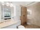 Bathroom featuring a tiled walk-in shower, a vanity and a mirrored cabinet at 297 Countryside Key Blvd, Oldsmar, FL 34677