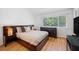 Bright bedroom featuring wood floors, a large window, and modern dark wood furnishings at 297 Countryside Key Blvd, Oldsmar, FL 34677
