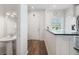 Inviting entryway featuring wood floors, a charming powder room, and a convenient breakfast bar at 297 Countryside Key Blvd, Oldsmar, FL 34677