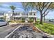 Townhome exterior featuring grey stucco, lush landscaping, and convenient parking at 297 Countryside Key Blvd, Oldsmar, FL 34677