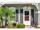 Inviting townhome entrance featuring mature palms, a black shuttered window, and a white door at 297 Countryside Key Blvd, Oldsmar, FL 34677