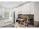 Well-lit kitchen showcasing stainless steel appliances, white cabinets, and granite countertops with backsplash at 297 Countryside Key Blvd, Oldsmar, FL 34677