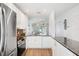 Bright kitchen boasts stainless appliances, granite countertops, and sleek white cabinetry at 297 Countryside Key Blvd, Oldsmar, FL 34677