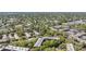 An aerial view of multi-unit housing complexes nestled in a dense suburban community with mature landscaping and a nearby waterway at 3076 Eastland Blvd # 305, Clearwater, FL 33761