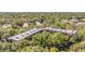 An aerial view showcasing a multi-unit building nestled amidst lush greenery and mature trees within a residential community at 3076 Eastland Blvd # 305, Clearwater, FL 33761