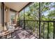 Relaxing screened balcony with seating offers peaceful views of surrounding trees and landscape at 3076 Eastland Blvd # 305, Clearwater, FL 33761
