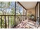 Relaxing screen enclosed balcony, featuring seating with a serene view of lush trees and neighborhood at 3076 Eastland Blvd # 305, Clearwater, FL 33761