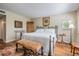 Comfortable bedroom with wood floors, neutral walls, and a wrought iron bed frame at 3076 Eastland Blvd # 305, Clearwater, FL 33761