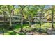 Exterior view of building with lush landscaping, mature trees, and pathways at 3076 Eastland Blvd # 305, Clearwater, FL 33761