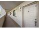 Hallway featuring unit door, neutral paint, and outdoor access at 3076 Eastland Blvd # 305, Clearwater, FL 33761