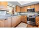 Kitchen with stainless steel appliances, granite countertops, wood cabinets, and wood floors at 3076 Eastland Blvd # 305, Clearwater, FL 33761