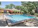 Inviting community pool surrounded by lush greenery, lounge chairs, and a pool house at 3076 Eastland Blvd # 305, Clearwater, FL 33761