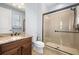 Bathroom with granite countertop, dark cabinets, toilet, shower with black frame, and natural light at 3226 Cordoba Ranch Blvd, Lutz, FL 33559