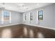 Large bedroom features hardwood floors, a ceiling fan, and abundant natural light from three windows at 3226 Cordoba Ranch Blvd, Lutz, FL 33559