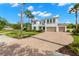 Stunning two-story home with a paved driveway, lush lawn, and tropical palm trees under a clear blue sky at 3226 Cordoba Ranch Blvd, Lutz, FL 33559