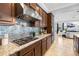 Close-up of a gourmet kitchen featuring stainless steel appliances, granite countertops, and dark wood cabinets at 3226 Cordoba Ranch Blvd, Lutz, FL 33559