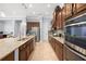 A modern kitchen featuring stainless steel appliances, granite countertops, dark wood cabinets, and a large island at 3226 Cordoba Ranch Blvd, Lutz, FL 33559