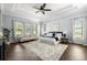 Spacious main bedroom with a ceiling fan, hardwood floors, a decorative rug, and abundant natural light from large windows at 3226 Cordoba Ranch Blvd, Lutz, FL 33559