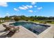 Inviting backyard pool features lounge chairs, beautiful landscaping and clear blue skies at 3226 Cordoba Ranch Blvd, Lutz, FL 33559