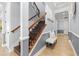 Elegant staircase with wooden steps, ornate iron railing, and white trim leads to upper level at 3226 Cordoba Ranch Blvd, Lutz, FL 33559