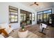 Bright sun room featuring dark wood floors, white accents, weight bench, and sliding glass doors at 3226 Cordoba Ranch Blvd, Lutz, FL 33559