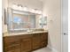 Modern bathroom features a large mirror over a double sink vanity, and a tiled shower at 3487 Recurve Cir, Sarasota, FL 34240