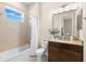Bright bathroom showcasing a shower-tub combo, neutral tiling, a granite vanity, and ample natural light from a window at 3487 Recurve Cir, Sarasota, FL 34240