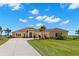 Inviting single-story home featuring a well-manicured lawn, tiled roof, and a spacious driveway at 3487 Recurve Cir, Sarasota, FL 34240
