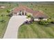 Beautiful one-story home with a terracotta tile roof, mature landscaping, and a long driveway on an expansive lot at 3487 Recurve Cir, Sarasota, FL 34240