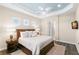 Comfortable main bedroom with wood floors, a ceiling fan, a light blue tray ceiling, and natural light at 3487 Recurve Cir, Sarasota, FL 34240