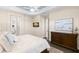 Comfortable main bedroom with wood floors, a ceiling fan, a light blue tray ceiling, and natural light at 3487 Recurve Cir, Sarasota, FL 34240