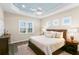 Comfortable main bedroom with wood floors, a ceiling fan, a light blue tray ceiling, and natural light at 3487 Recurve Cir, Sarasota, FL 34240