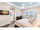 Comfortable main bedroom with wood floors, a ceiling fan, a light blue tray ceiling, and natural light at 3487 Recurve Cir, Sarasota, FL 34240