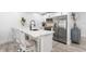 Stylish kitchen with white cabinets, quartz counters, stainless steel appliances, and a chic island with seating at 3735 42Nd S Way # J, St Petersburg, FL 33711