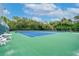 Well-maintained tennis court with green and blue surfaces, surrounded by trees, offering a great space for recreation at 3735 42Nd S Way # J, St Petersburg, FL 33711