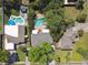 An overhead view displays the property, lush landscaping, and a private kidney-shaped pool with sun loungers at 3818 W San Miguel St, Tampa, FL 33629