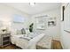 Bright bedroom featuring white walls, parquet floors, a sunny window, and stylish decor at 3818 W San Miguel St, Tampa, FL 33629