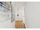 Hallway featuring hardwood floors, stylish artwork, and a convenient linen closet at 3818 W San Miguel St, Tampa, FL 33629