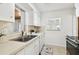 Bright kitchen features white cabinetry, stainless steel appliances, double sink and natural light at 3818 W San Miguel St, Tampa, FL 33629