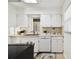 Well-lit kitchen boasts white cabinetry, stainless steel oven and dishwasher, and an attractive rug at 3818 W San Miguel St, Tampa, FL 33629