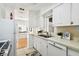This kitchen provides white cabinets, stainless steel appliances, and views to other rooms at 3818 W San Miguel St, Tampa, FL 33629