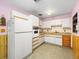 Compact kitchen featuring white appliances, wooden accents, and ample cabinetry at 4509 N Saint Vincent St, Tampa, FL 33614