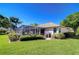 Well-maintained backyard featuring a screened patio, greenery, and palm trees at 4904 Breyer Wood Ct, Valrico, FL 33596