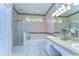 Well-lit bathroom with a glass-enclosed shower, tub, and dual sink vanity at 4904 Breyer Wood Ct, Valrico, FL 33596